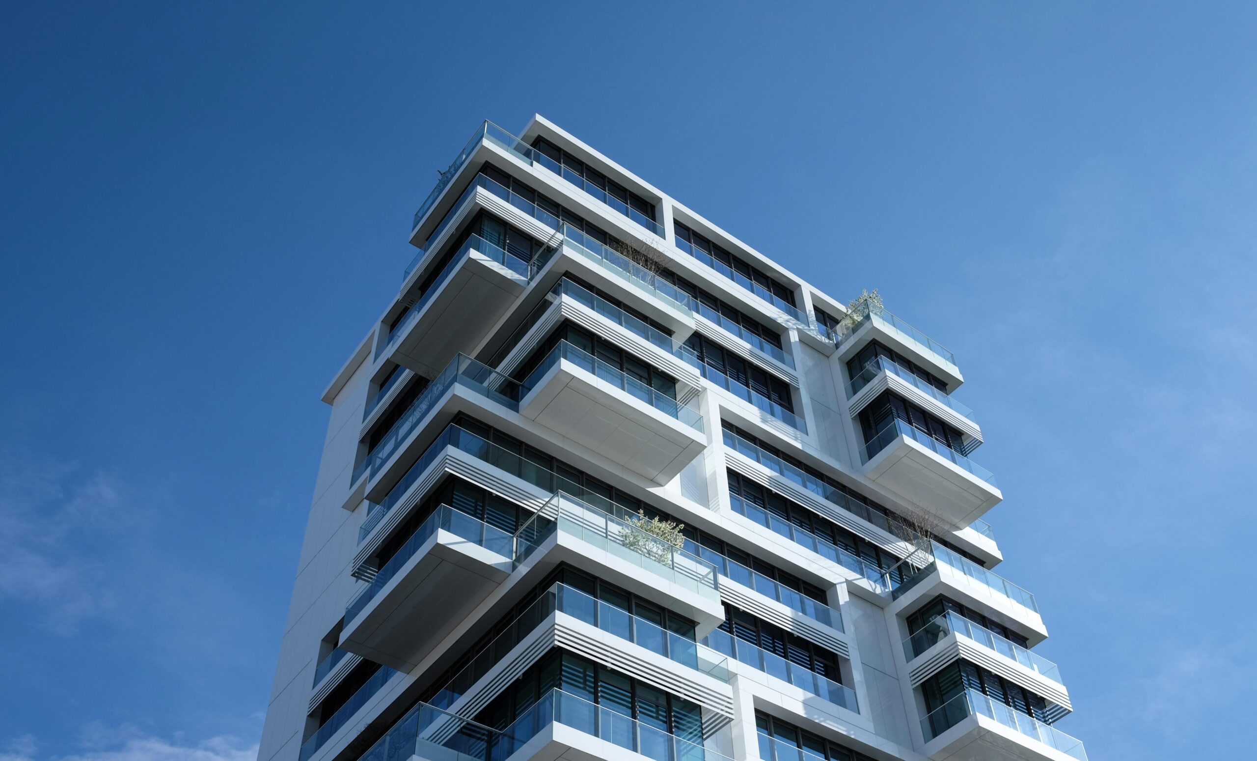 Modern California high-rise with stacked balconies — many cities now run local E3 programs
